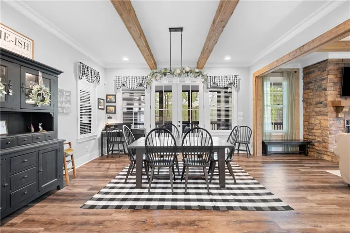A spacious dining area easily accommodates a large table and additional furnishings, with French doors opening to the screened porch.