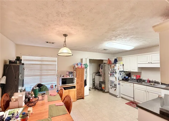Large Eat-In Kitchen into Laundry and 2 Car Garage - Photo Edited to Remove Items Not Material to Property