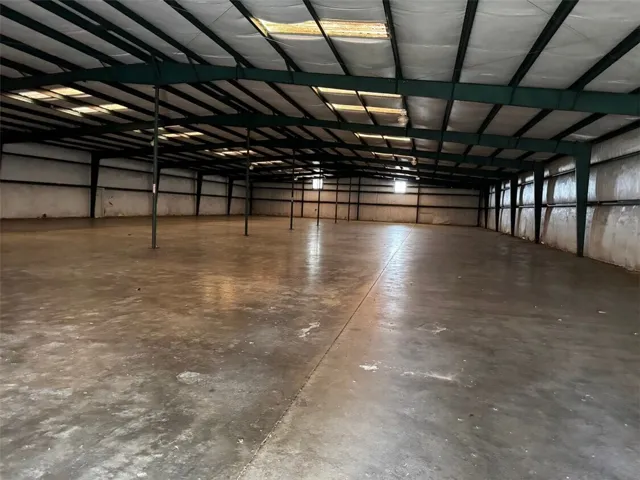 This spacious warehouse features durable concrete flooring, an open layout, and abundant natural light for versatile use.
