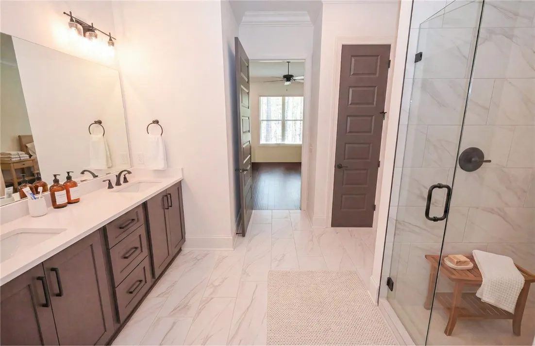 Primary bath with dual vanities, curbless tiled shower, & huge walk-in closet!