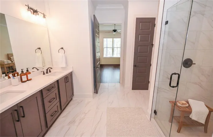 Primary bath with dual vanities, curbless tiled shower, & huge walk-in closet!