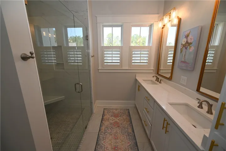 Stylish primary bathroom with curbless tile/glass walk-in shower.
