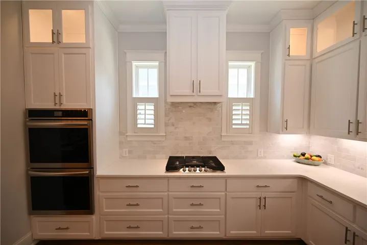 Quartz countertops, double ovens, and gas cooktop.