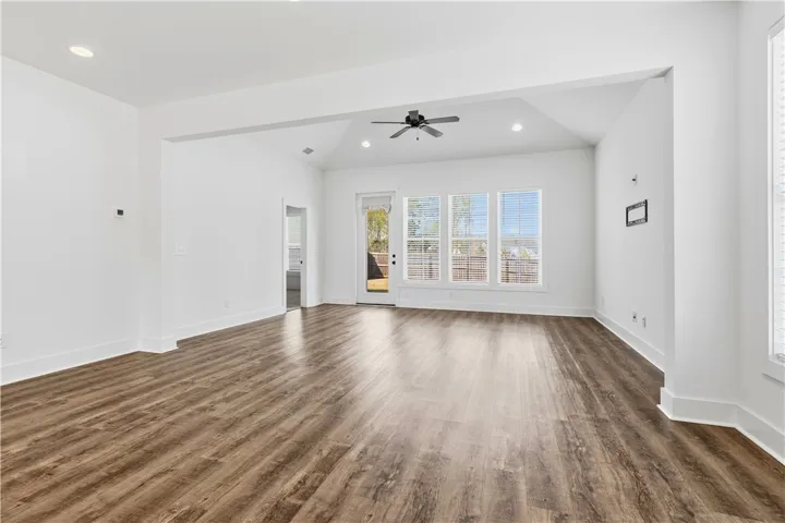 View from kitchen through breakfast and into living.  Primary suite through door near back door - perfect for letting pups out!