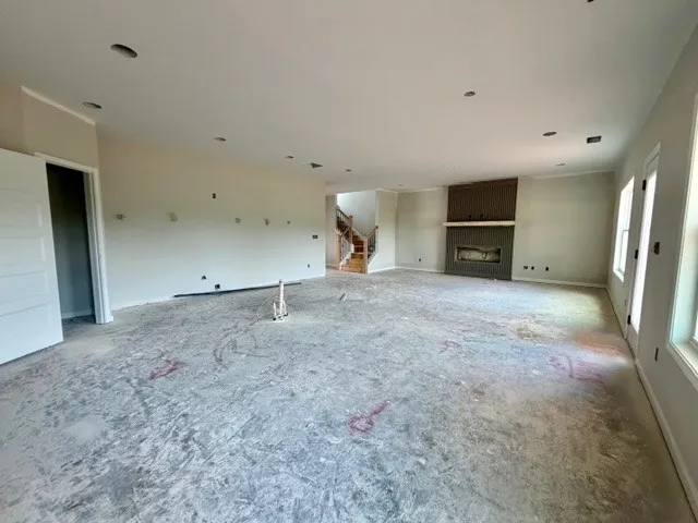 The open concept living area features a modern fireplace and abundant natural light.