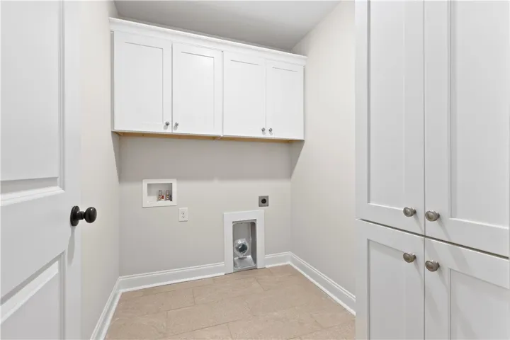 This laundry room features custom cabinets with ample space and conveniently located upstairs for your laundry and storage needs.