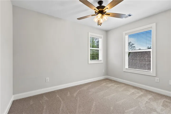 This bright bedroom features abundant natural light through both windows, allowing the sun to shine in for a feeling of peacefulness and comfort.