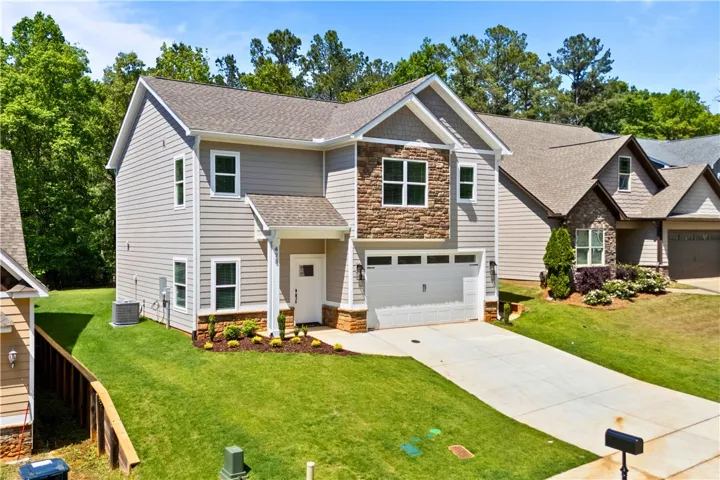 This newly constructed residence showcases a contemporary design with a welcoming entrance and ample outdoor space.