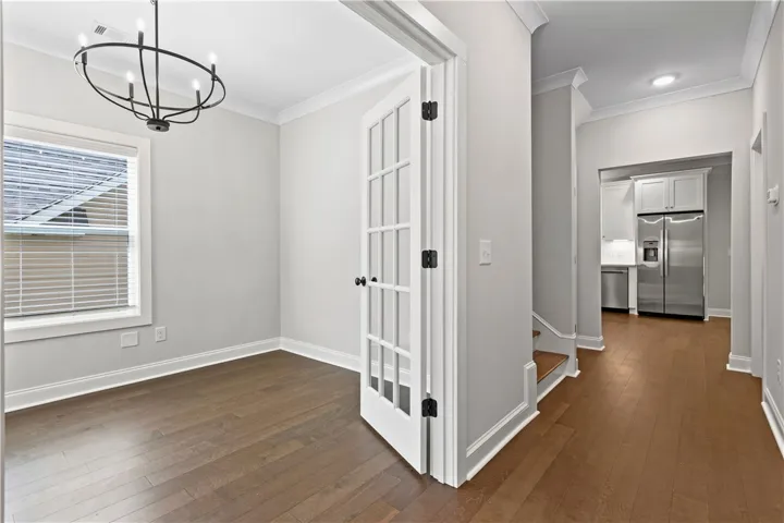 This versatile room features elegant French doors, a beautiful modern chandelier, gleaming hardwood floors that flows down the hallway and throughout most of the downstairs.
