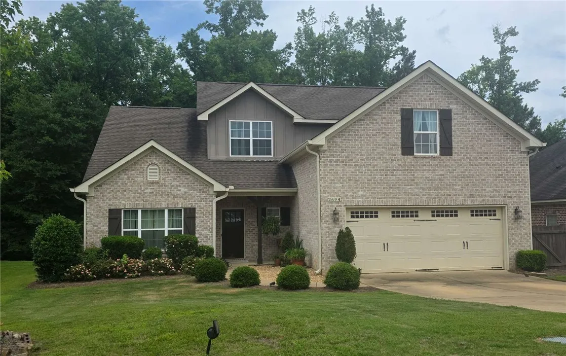 A well-maintained facade with neat landscaping and inviting entry beckons to a charming dwelling.