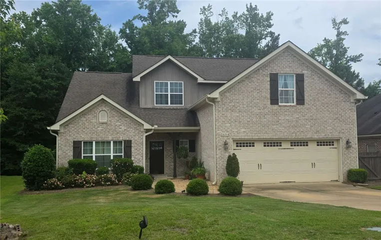 A well-maintained facade with neat landscaping and inviting entry beckons to a charming dwelling.