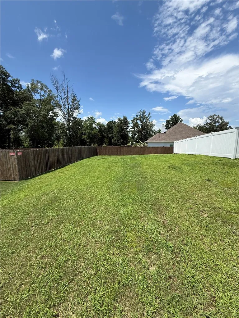 Side yard...plenty of room for outbuilding and/or expand the white vinyl fence over to the property line to allow more backyard space.