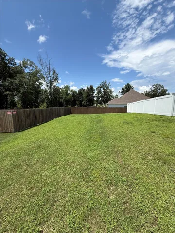 Side yard...plenty of room for outbuilding and/or expand the white vinyl fence over to the property line to allow more backyard space.