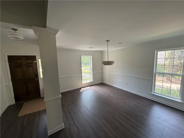 A well-lit entry and dining space features rich dark flooring and crisp white trim.