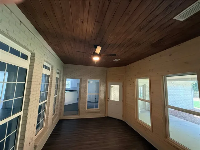 A charming sunroom with a natural wood ceiling offers a tranquil retreat.