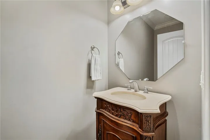 The half bath has a beautiful vanity and hardwood floors.