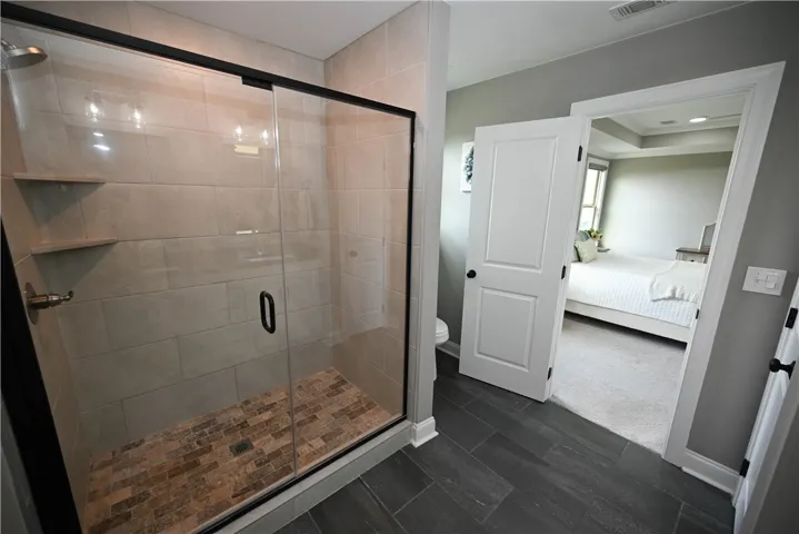 Primary bath with double sink extended vanity & a beautiful tiled shower