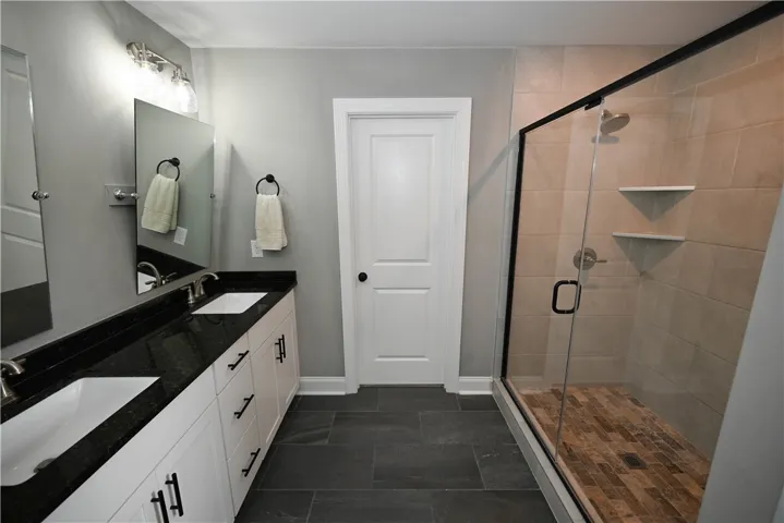 Primary bath with double sink extended vanity & a beautiful tiled shower