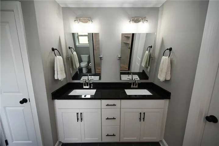 Primary bath with double sink extended vanity & a beautiful tiled shower