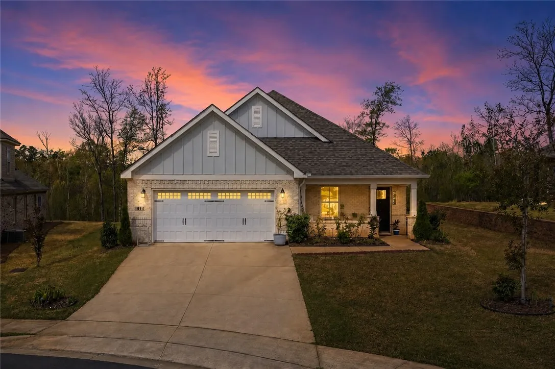 Front facade with a well-maintained yard and concrete driveway at twilight.