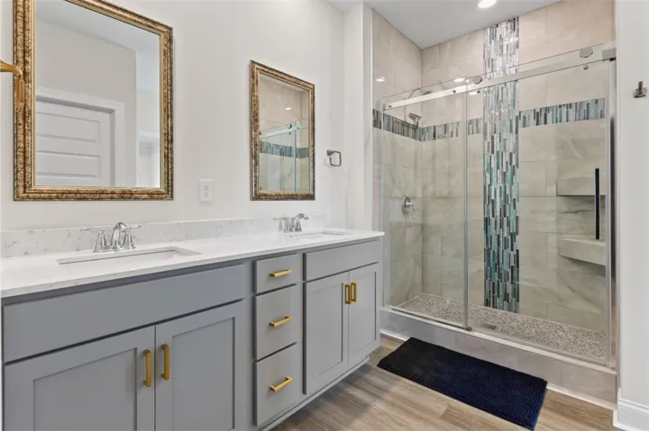 A fully tiled walk-in shower, sliding glass enclosure, eye-catching accent tile, and tile extended to the ceiling