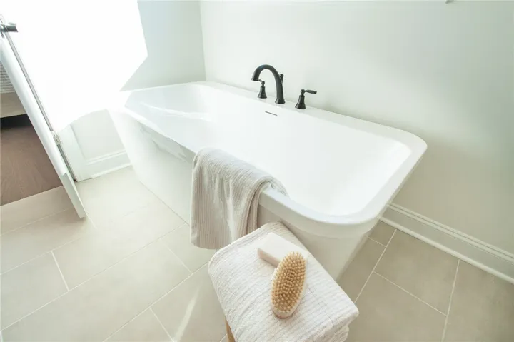 This tranquil bathroom features a freestanding tub, offering a relaxing and restorative bathing experience. Photos are not of subject property. Photos are of the same floorplan of a completed home.