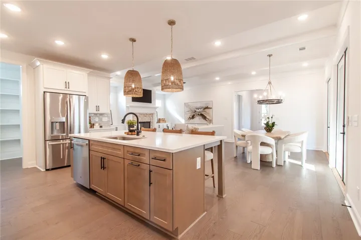An open concept floorplan features a kitchen island, dining area, and living room perfect for entertaining.