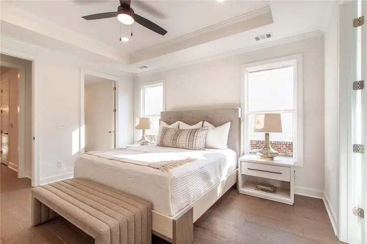 This tranquil bedroom features high ceilings and elegant hardwood flooring, perfect for serene living. Photos are not of subject property. Photos are of the same floorplan of a completed home.
