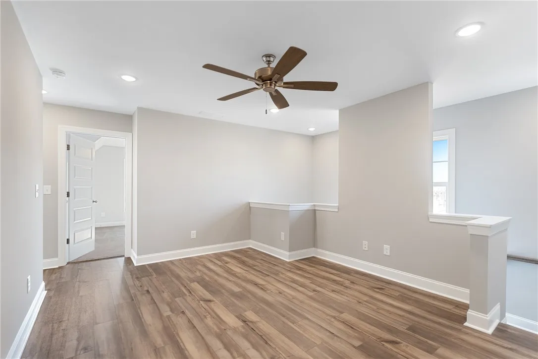 This versatile loft area features durable wood flooring and abundant natural light. Photos are not of subject property. Photos are of the same floorplan of a completed home.