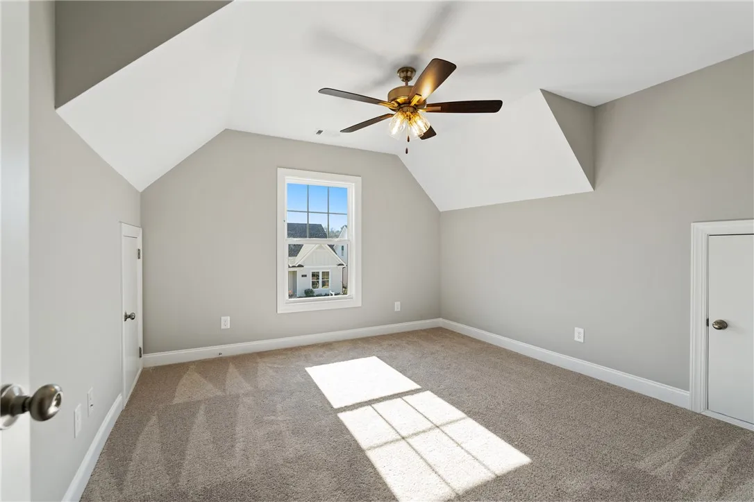 Bright and airy room with sloped ceilings and ample natural light. Photos are not of subject property. Photos are of the same floorplan of a completed home.
