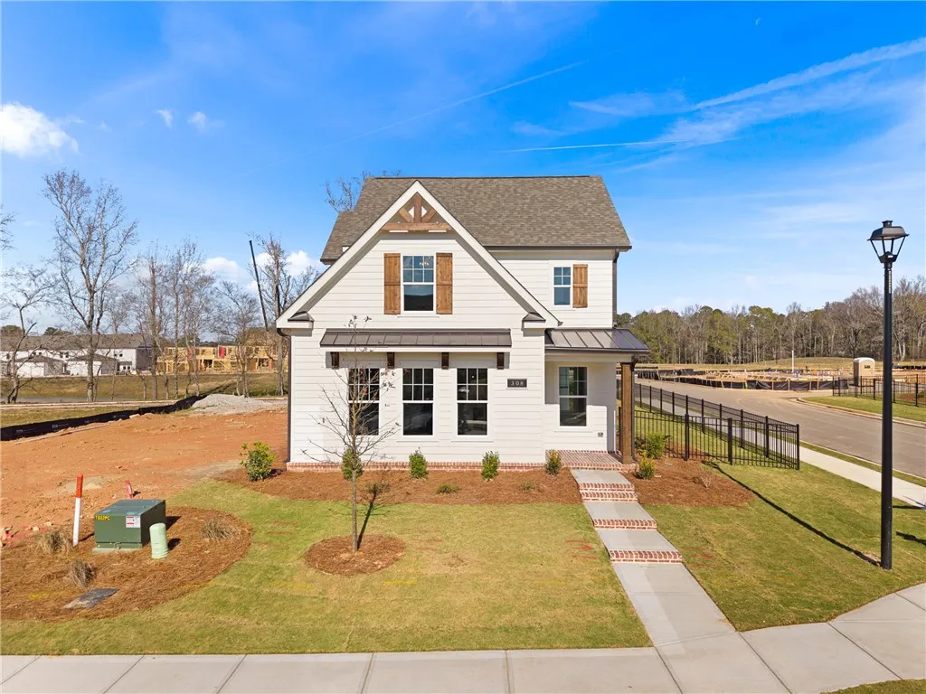 This charming residence features a well-manicured lawn and welcoming facade. Photos are not of subject property. Photos are of the same floorplan of a completed home.