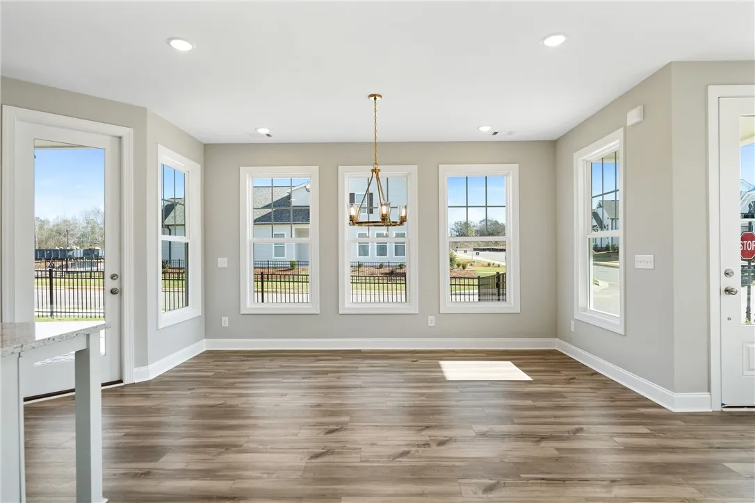 This airy room features ample natural light and durable flooring, perfect for versatile living. Photos are not of subject property. Photos are of the same floorplan of a completed home.