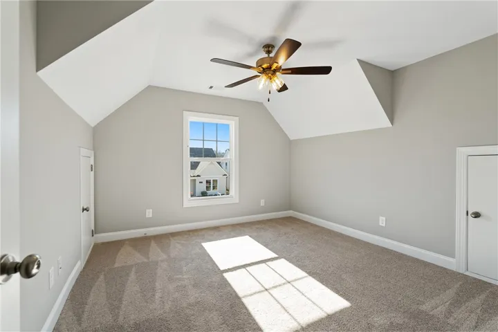 Bright and airy room with sloped ceilings and ample natural light. Photos are not of subject property. Photos are of the same floorplan of a completed home.