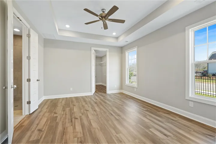 An inviting room features gleaming floors and a modern ceiling design. Photos are not of subject property. Photos are of the same floorplan of a completed home.