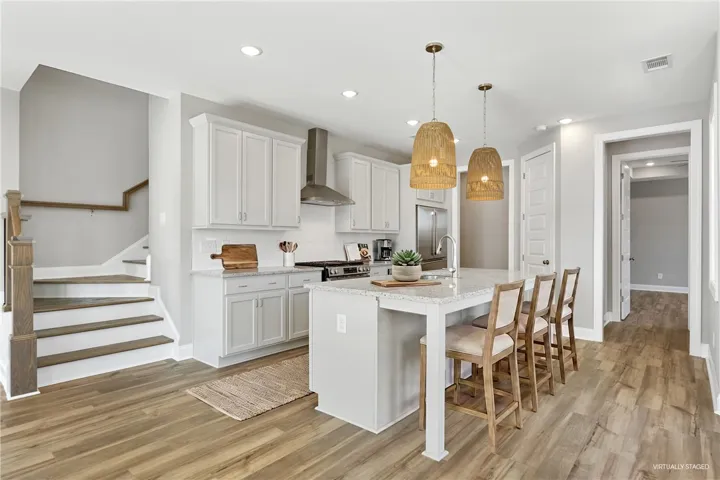 This bright kitchen features a functional island and hardwood floors.