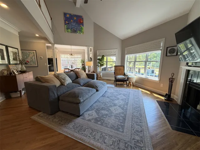 This living room features vaulted ceilings, rich hardwood flooring, and abundant natural light.