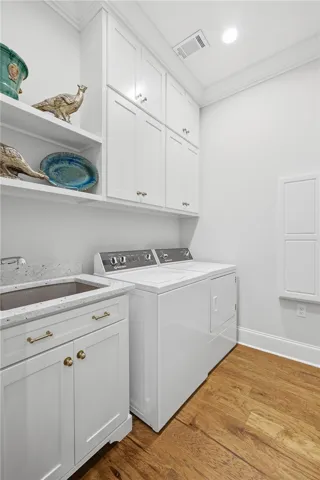 Open shelving and ceiling-height cabinetry create a tidy, well-organized laundry.