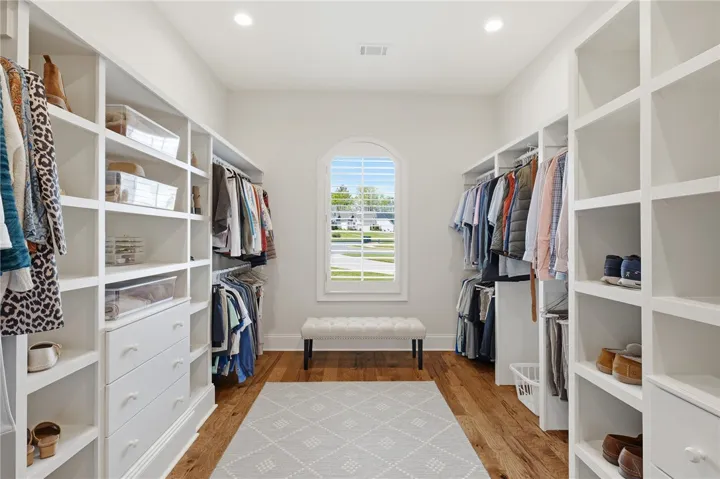 With custom shelving and hardwood flooring, the primary closet is an elegant spot to prep for the day ahead.