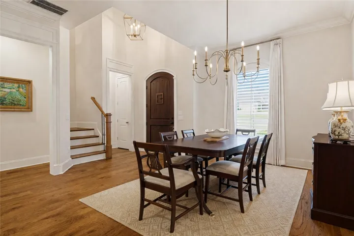 Located at the entry, the dining room is anchored by a statement chandelier beside the two-story foyer.