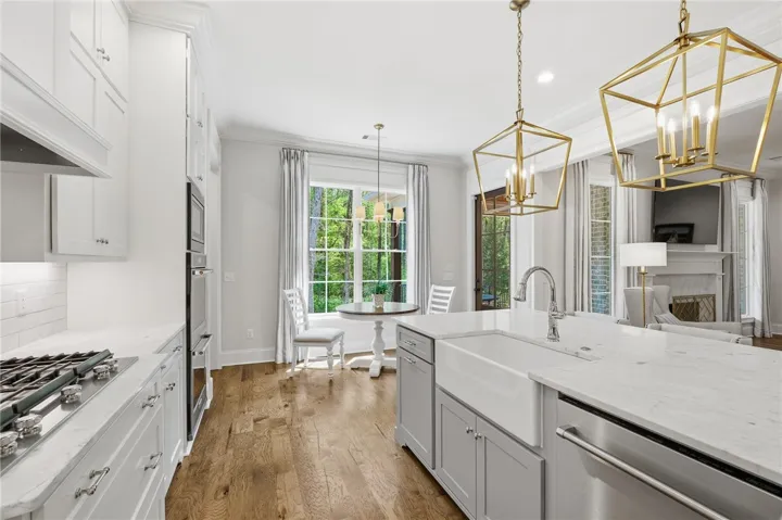 Island with apron-front sink and marble countertops.