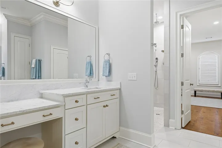 Tremendous mirrors make the primary bath feel expansive. One vanity features a dressing table.