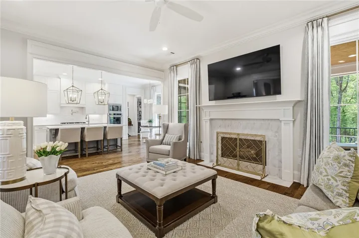 Tall windows flank the fireplace, and a cased opening to the kitchen enhances the light-filled living room.