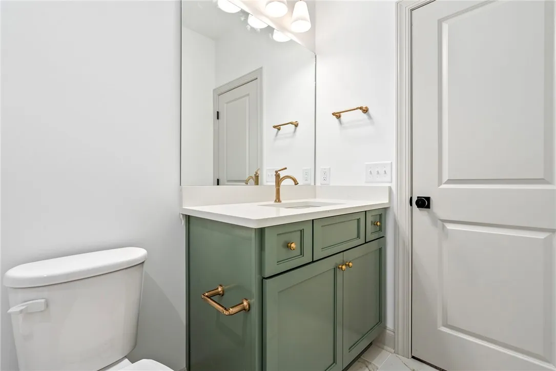 The second-floor full bath offers cabinetry in a fun pop of color.