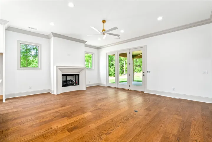 With windows flanking the fireplace and a wall of glass-front doors opening to the porch, natural light is not lacking.