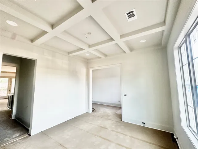 A coffered ceiling and large window in the formal dining room create a lovely first impression.