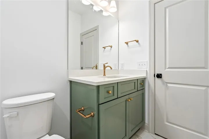 The second-floor full bath offers cabinetry in a fun pop of color.