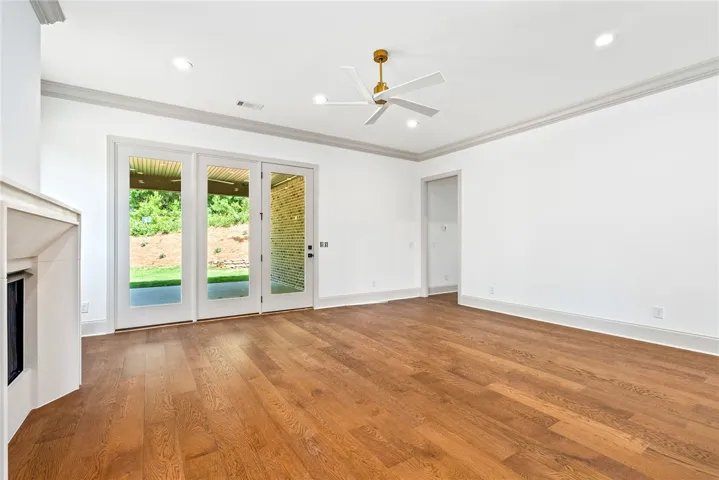 A cast-stone fireplace, triple doors to the porch, and gorgeous wood floors define the great room.
