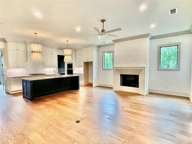 Windows flanking the gas fireplace and a triple-door system flood the living room with natural light.