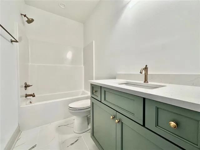 The second-floor full bath offers cabinetry in a fun pop of color.