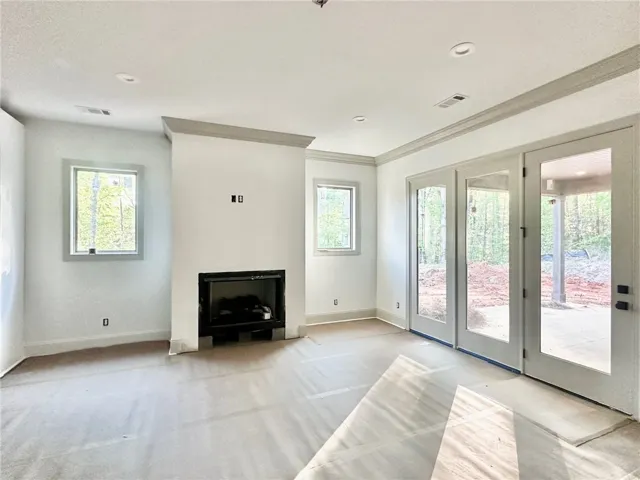 Windows flanking the gas fireplace and a triple-door system flood the living room with natural light.